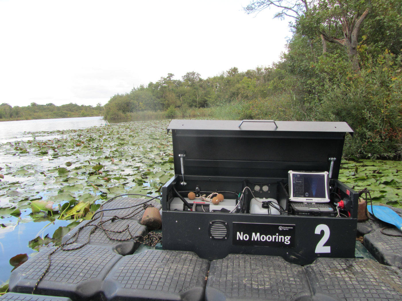 conservation equipment on a jetty next to water covered in lily pads